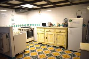 Il comprend une cuisine avec des appareils électroménagers blancs et du carrelage. dans l'établissement La Perla Antica, à Vietri