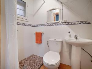 Baño blanco con aseo y lavamanos en Casa Rustica en Vilaverd en Vilavert