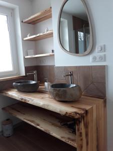 une salle de bain avec deux lavabos sur un comptoir en bois avec un miroir dans l'établissement Grand gîte des pins, à Chaumousey 32 autres photos