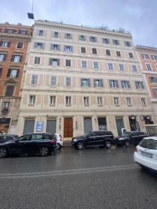 un grande edificio con macchine parcheggiate di fronte di SWEETSUITE Rome a Roma