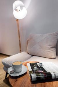 Moderne Stadtwohnung an der Fussgängerzone, Smart TV, Kingsize-Bett, Couch, Küche في باساو: كوب من القهوة ومجلة على طاولة