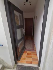 a hallway with a door and a tile floor at Charmantes Apartment mit Extra-Eingang in Neusäß