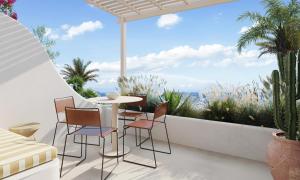 NUMO Mykonos Boutique Resort في كالافاتيس: فناء على طاولة وكراسي على شرفة