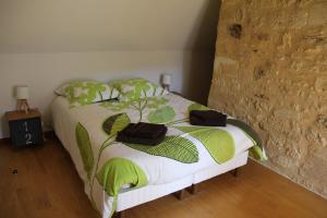 a bedroom with a bed with green leaves on it at Le Coeur de Domme in Domme