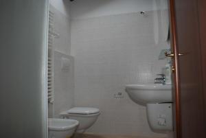 a white bathroom with a sink and a toilet at Giacomo Home in Marina di Cecina