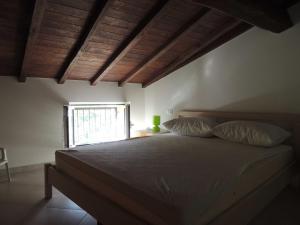 a bedroom with a bed with two pillows and a window at Giacomo Home in Marina di Cecina