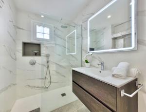 un bagno bianco con doccia e lavandino di The Stylish Apartment a Puerto de la Cruz