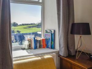 a window with a shelf with books and a lamp at Bron Haul, Mountain Views in Brynteg