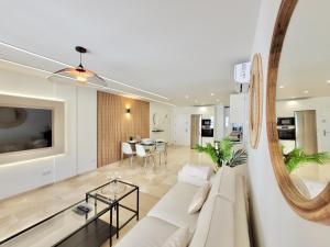 un soggiorno con divano bianco e specchio di The Stylish Apartment a Puerto de la Cruz