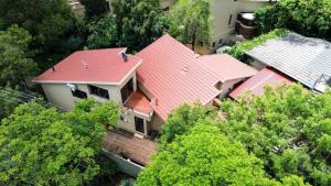 einen Blick über ein Haus mit rotem Dach in der Unterkunft Airbnb at Bailyes in Pretoria