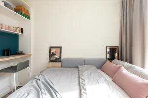 a small bedroom with a bed with pink pillows at MILESTONE Krakow Center Student Living in Krakow