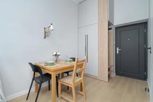 een eetkamer met een tafel en stoelen en een deur bij Stylish Grey Apartments with a City View in Poznań by Renters in Poznań