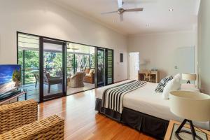 a bedroom with a bed and a sliding glass door at Bramston Beach - Premium Holiday House in Bramston Beach