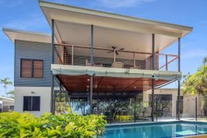 a house with a balcony and a swimming pool at Bramston Beach - Premium Holiday House in Bramston Beach