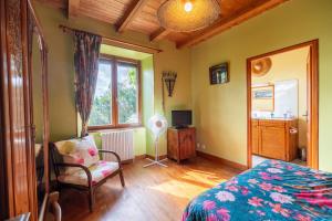 a bedroom with a bed and a chair and a window at La Ferme de Leychoisier in Bonnac-la-Côte