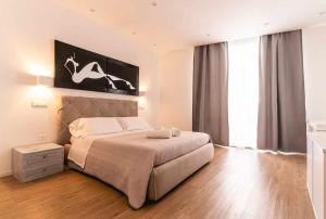a bedroom with a bed and a large window at CeO LUXURY SUITE DI CAGLIARI in Cagliari