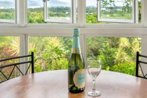 una bottiglia di vino seduta su un tavolo con un bicchiere di Edge Hill - spectacular views of the city and sea a Edge Hill