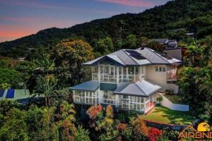 a large house in the middle of a forest at Edge Hill - spectacular views of the city and sea in Edge Hill