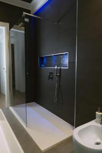 La salle de bains est pourvue d'une douche en verre et d'un lavabo. dans l'établissement CeO LUXURY SUITE DI CAGLIARI, à Cagliari