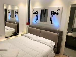 una camera con un letto bianco e due specchi di CeO LUXURY SUITE DI CAGLIARI a Cagliari