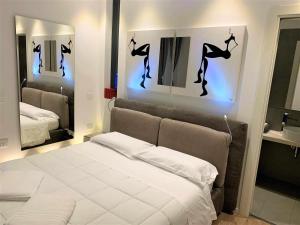 - une chambre avec un lit blanc et deux miroirs dans l'établissement CeO LUXURY SUITE DI CAGLIARI, à Cagliari