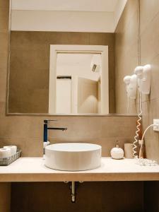 La salle de bains est pourvue d'un lavabo et d'un miroir. dans l'établissement CeO LUXURY SUITE DI CAGLIARI, à Cagliari