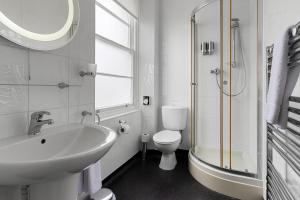 a white bathroom with a sink and a toilet at Babbacombe Royal Hotel and Carvery in Torquay