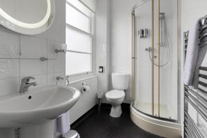 a white bathroom with a sink and a toilet at Babbacombe Royal Hotel and Carvery in Torquay +46 photos