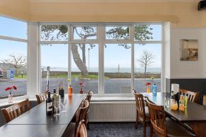 a table in a restaurant with a large window at Babbacombe Royal Hotel and Carvery in Torquay