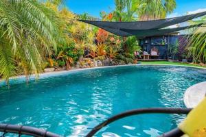 a large swimming pool with a hammock in a yard at Serenity @ Bayview in Bayview Heights