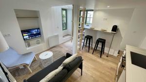 Una sala de estar con un sofá y una mesa y una cocina. en Appartement au calme dans le quartier historique pour 4 personnes avec espace extérieur, en Pau