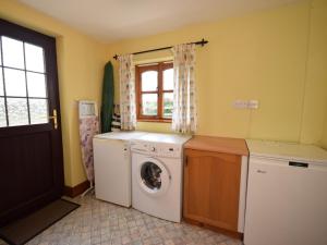 uma lavandaria com uma máquina de lavar roupa e uma janela em 2 Bed in Bradworthy KANNA em Bradworthy