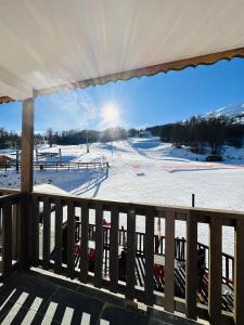 a view of a snow covered ski slope from a deck at Chalet Sainte Anne in Condamine-Châtelard