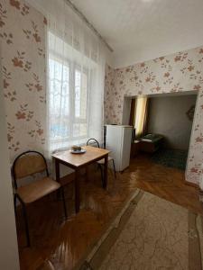 - une cuisine avec une table et un réfrigérateur dans la chambre dans l'établissement 2-х комнатный номер с 4 кроватями, à Uralsk