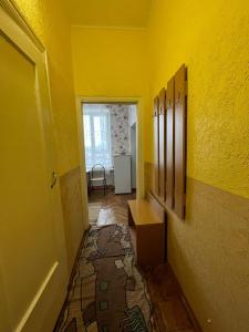 une chambre avec un mur jaune et un couloir dans l'établissement 2-х комнатный номер с 4 кроватями, à Uralsk