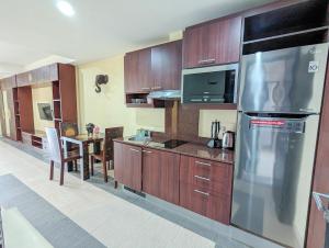 a kitchen with wooden cabinets and a stainless steel refrigerator at Seaview Apartment in Siam Royal View in Ban Khlong Son