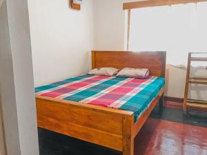 a bed with a wooden frame in a room at Lodgepole Pine Resorts in Welimada