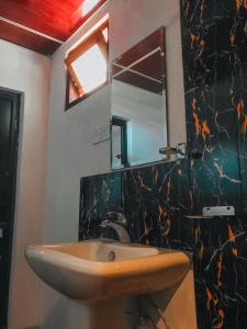 a bathroom with a sink and a mirror at Lodgepole Pine Resorts in Welimada