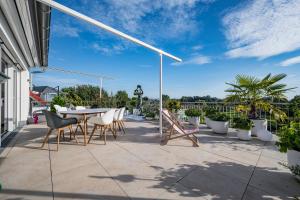 un patio con mesa, sillas y plantas en Design meets Style Bodensee mit Homeoffice bis 6 Personen, en Friedrichshafen