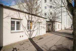 Three Bedroom plus big kitchen plus SelfCheckIn plus Street Parking في برلين: ظل شجرة على جانب المبنى