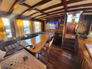 a living room with a table in a train car at Bateau pirate in Crespinet