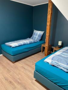 Dormitorio azul con cama y escalera en Ferienwohnung Haus Peters "De Groote", en Marschkamp