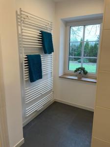 a bathroom with a window and two blue towels at Ferienwohnung Haus Peters "De Groote" in Marschkamp