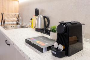 a kitchen counter with a coffee maker on a stove at New Modern & Cozy apartment with free parking in Varna City