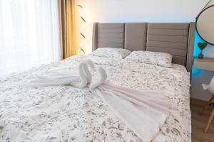 ein Bett mit zwei weißen Schwänen drauf in der Unterkunft New Modern & Cozy apartment with free parking in Warna