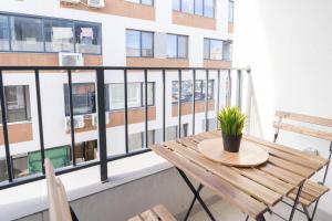 einen Tisch und Stühle auf einem Balkon mit einem Gebäude in der Unterkunft New Modern & Cozy apartment with free parking in Warna