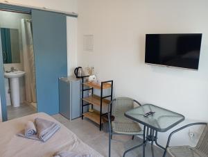 a room with a bed and a table and a television at BlueSuite in Ayia Napa