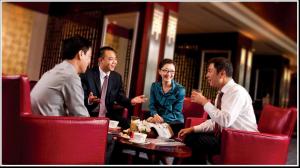 un grupo de personas sentadas alrededor de una mesa en Grand Metropark Yuantong Hotel Beijing en Pekín