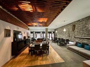 a restaurant with tables and chairs and a brick wall at Pensiunea Rasnoava in Predeal