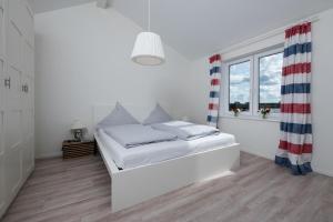 a white bedroom with a bed and a window at Schiff in Gelting